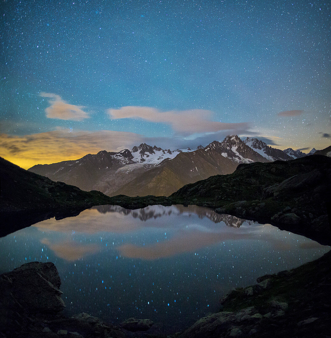 The stars illuminate the snowy peaks and reflected in Lac de Cheserys Chamonix Haute Savoie France Europe