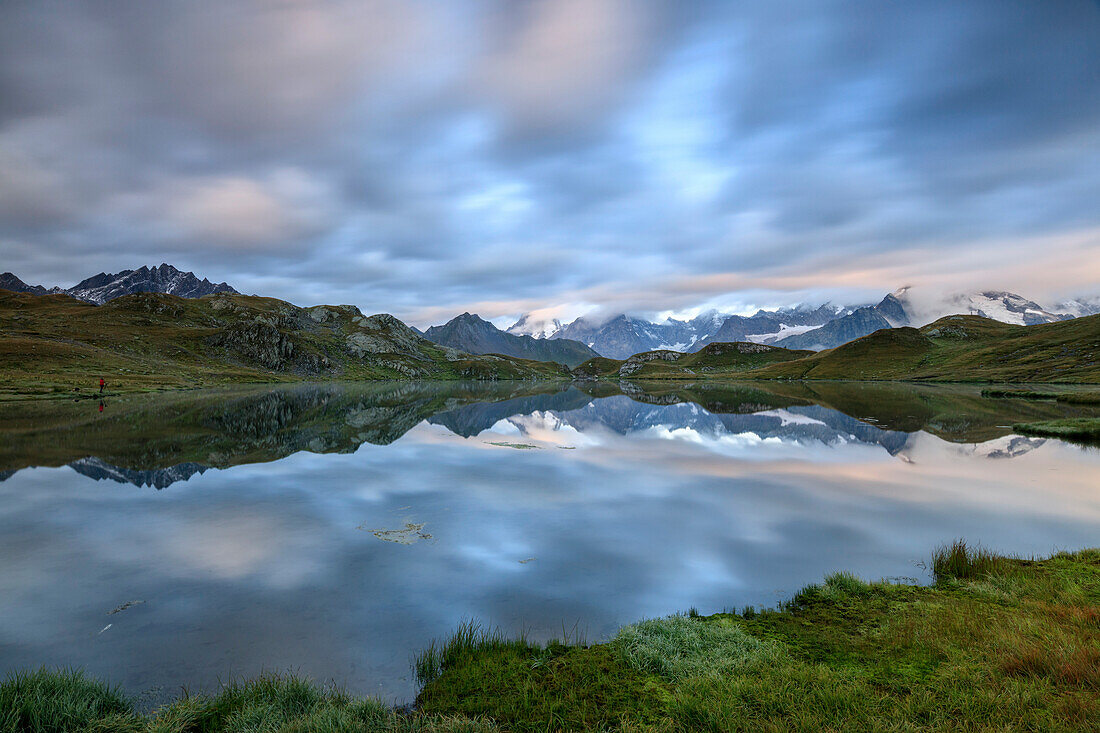 The snowy peaks are reflected in Fenetre Lakes at dawn Ferret Valley Saint Rh?®my Grand St Bernard Aosta Valley Italy Europe