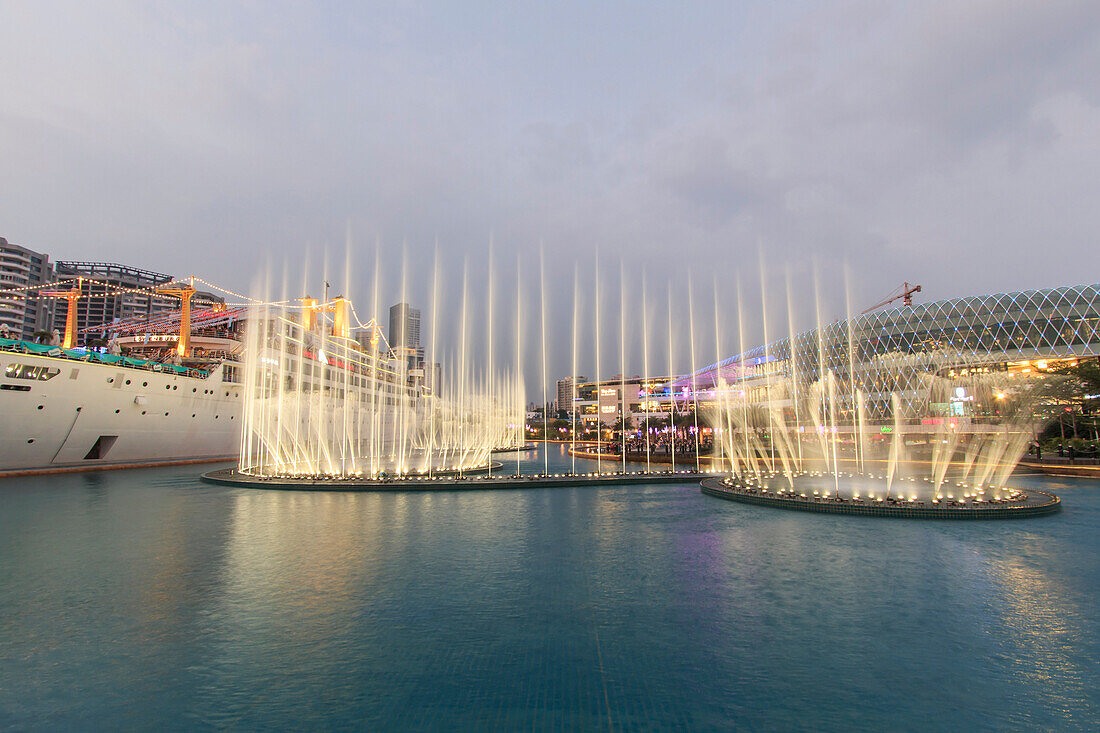 Dancing Fountains in New Sea World Plaza, one of the landmark of Shenzhen, at sunset with the Minghua ship on its center. The ship was originally known as Anceevilla and was later renamed ÔÇ£MinghuaÔÇØ by the chinese who bought it, China