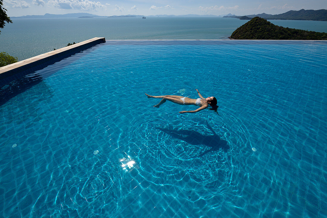 Frau im Infinity Pool in Hotelanlage auf Ko Yao Yai in der Andamanischen See, Thailand
