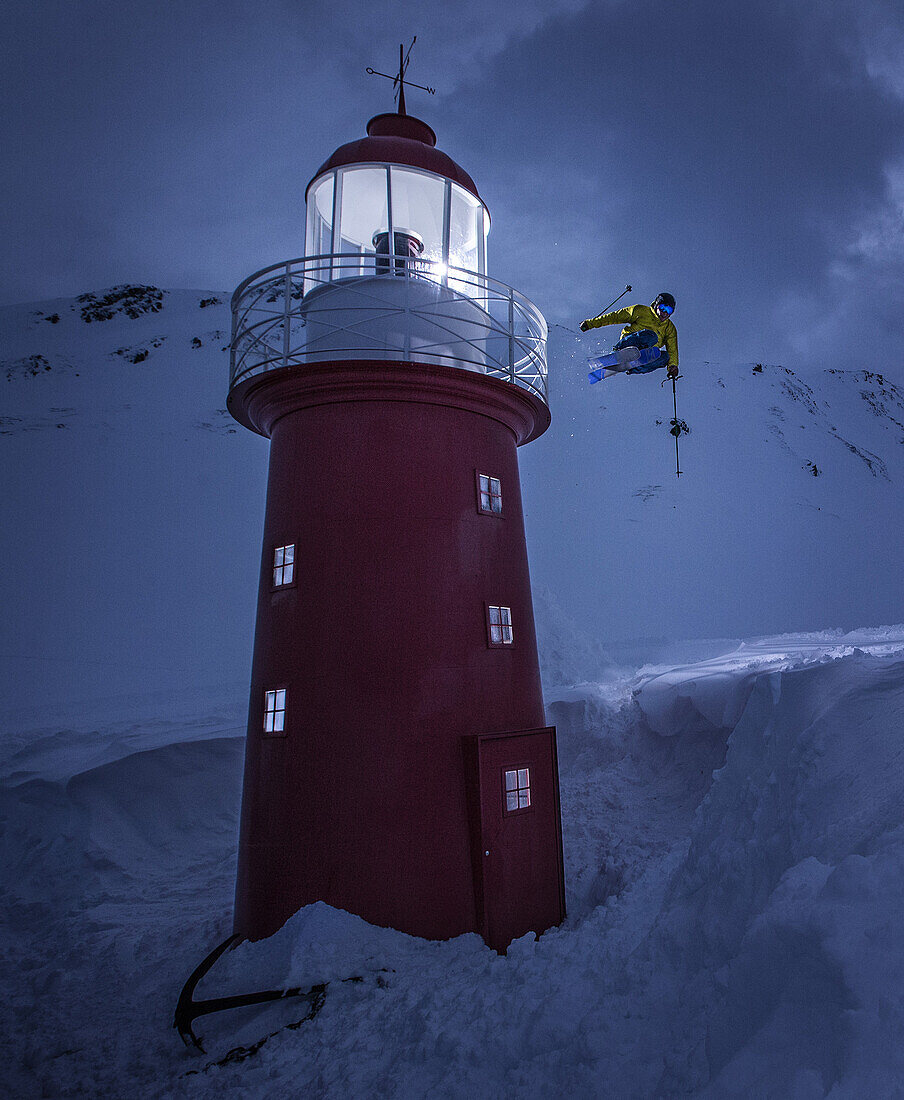 Junger Skifahrer springt an einem Leuchturm vorbei im Tiefschnee, Andermatt, Uri, Schweiz