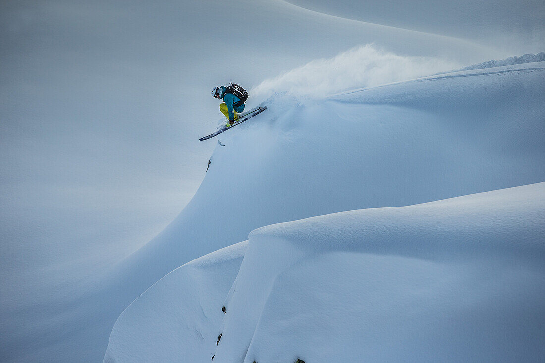 Junger Skifahrer springt im Tiefschnee abseits der Piste, Andermatt, Uri, Schweiz