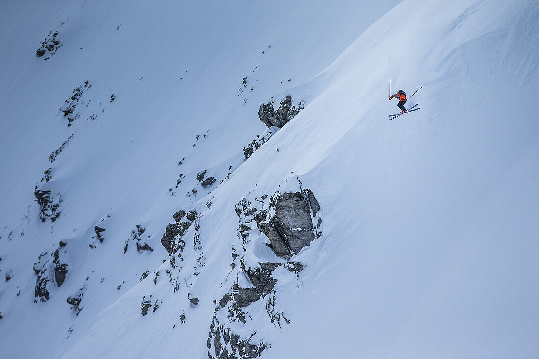 Junger Skifahrer springt im Tiefschnee abseits der Piste, Andermatt, Uri, Schweiz