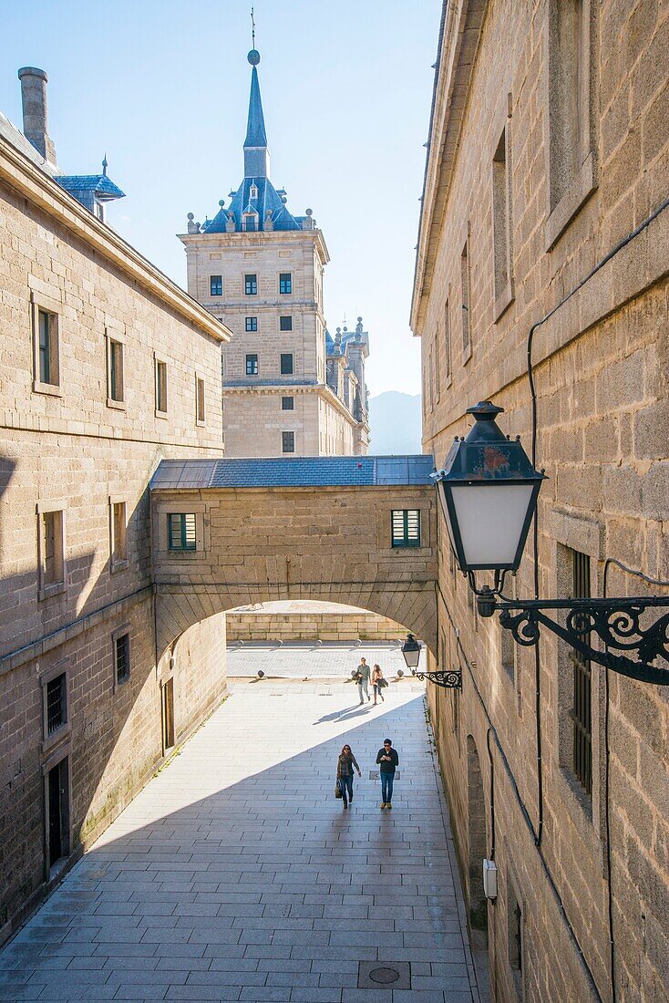 Street, arch and Royal Monastery. San Lorenzo del Escorial, Madrid province, Spain.