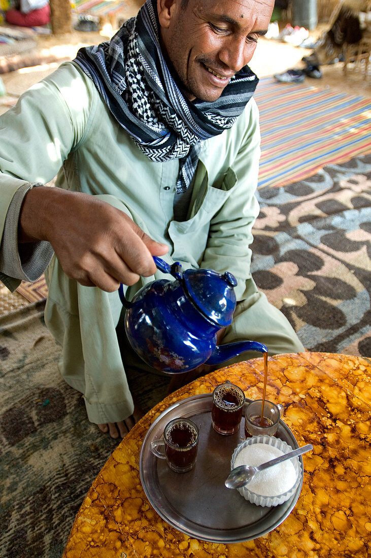 Egypt, Libyan Desert, man serving the mint tea