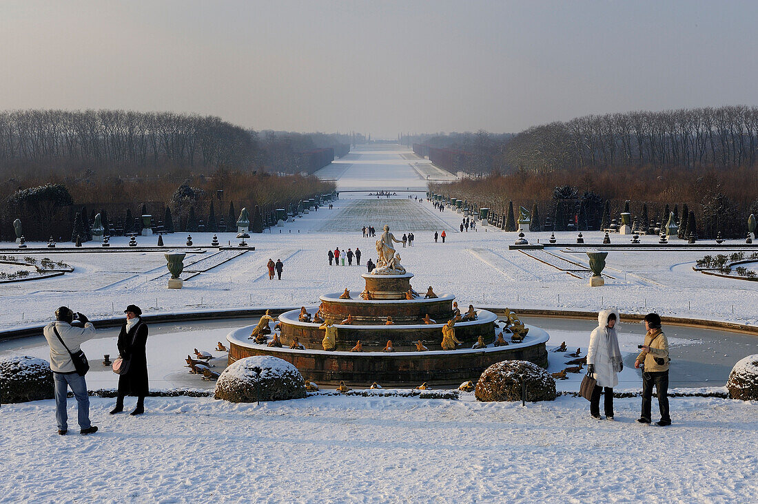 France, Yvelines, snow covered park of the Chateau de Versailles, listed as World Heritage by UNESCO, the Latona Basin and gardens perspective and the Axe du Soleil (the Sun Axis) to the frozen Grand Canal
