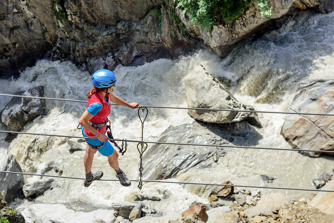Woman climbing on ropeway on Obergurgler Klettersteig, fixed-rope route, river in background, Obergurgler Klettersteig, Obergurgl, Oetztal Alps, Tyrol, Austria