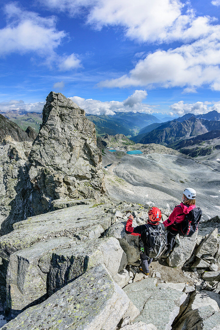 Man and woman climbing on fixed-rope route and enjoying view, Sentiero dei Fiori, Adamello-Presanella Group, Trentino, Italy