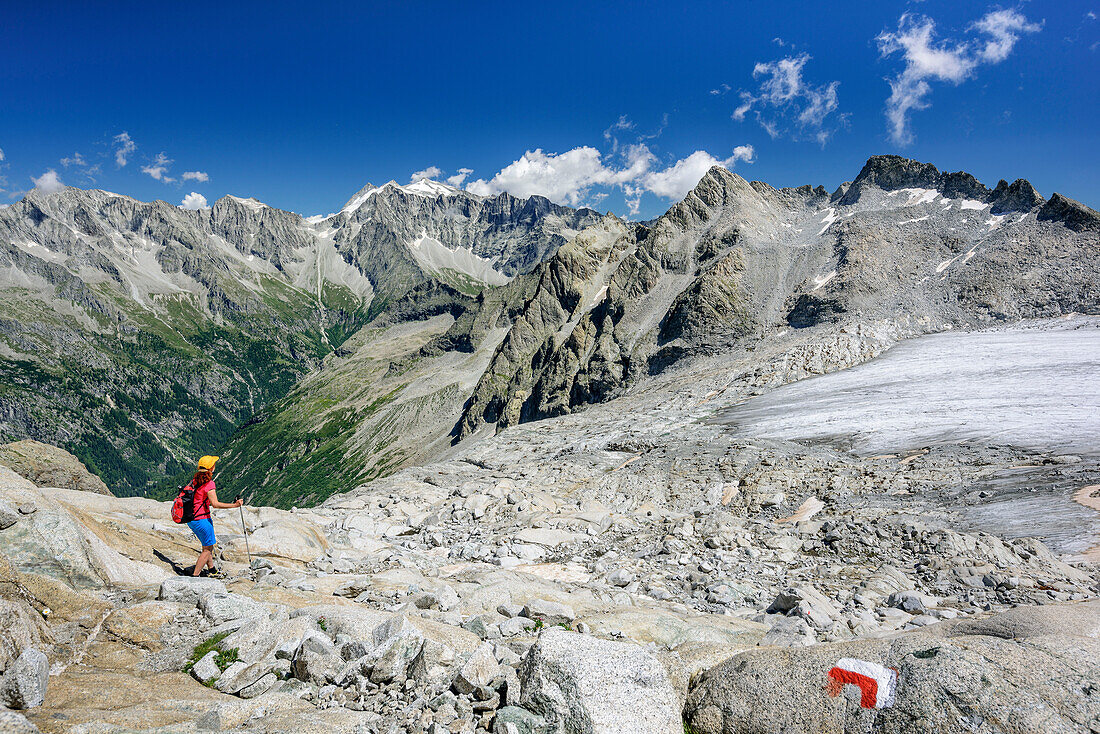 Frau steigt über Gletscherschliff vom Rifugio Lobbia Alta ab, Cima Presanella im Hintergrund, Rifugio Lobbia Alta, Val Genova, Adamello-Presanella-Gruppe, Trentino, Italien