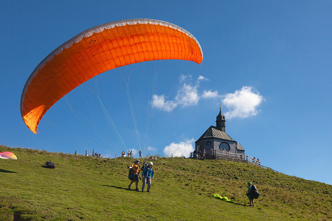 Paragliding mit Gleitschirmfliegern, Kapelle auf dem Wallberg, bei Rottach-Egern am Tegernsee, Mangfallgebirge, Bayern, Deutschland