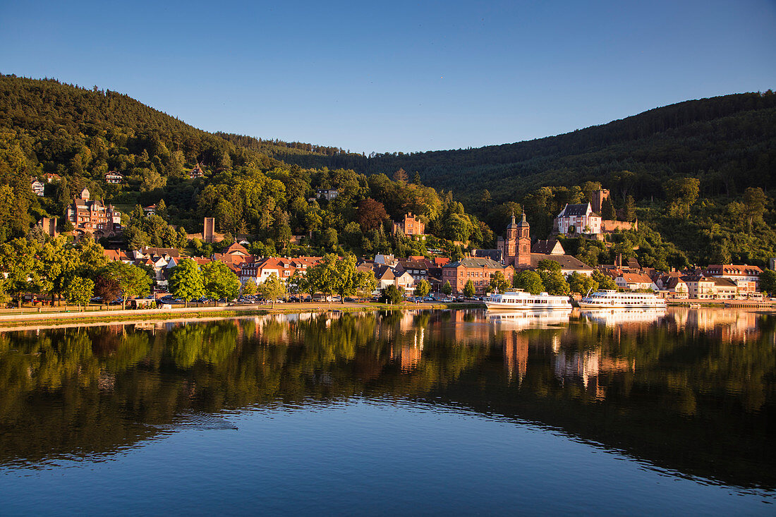 View from Mainbruecke bridge to city and excursion boats on Main river with reflection, Miltenberg, Spessart-Mainland, Bavaria, Germany