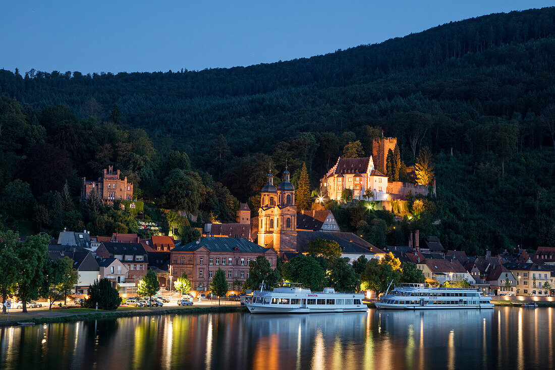 View from Mainbruecke bridge to city and excursion boats on Main river with reflection at dusk, Miltenberg, Spessart-Mainland, Bavaria, Germany