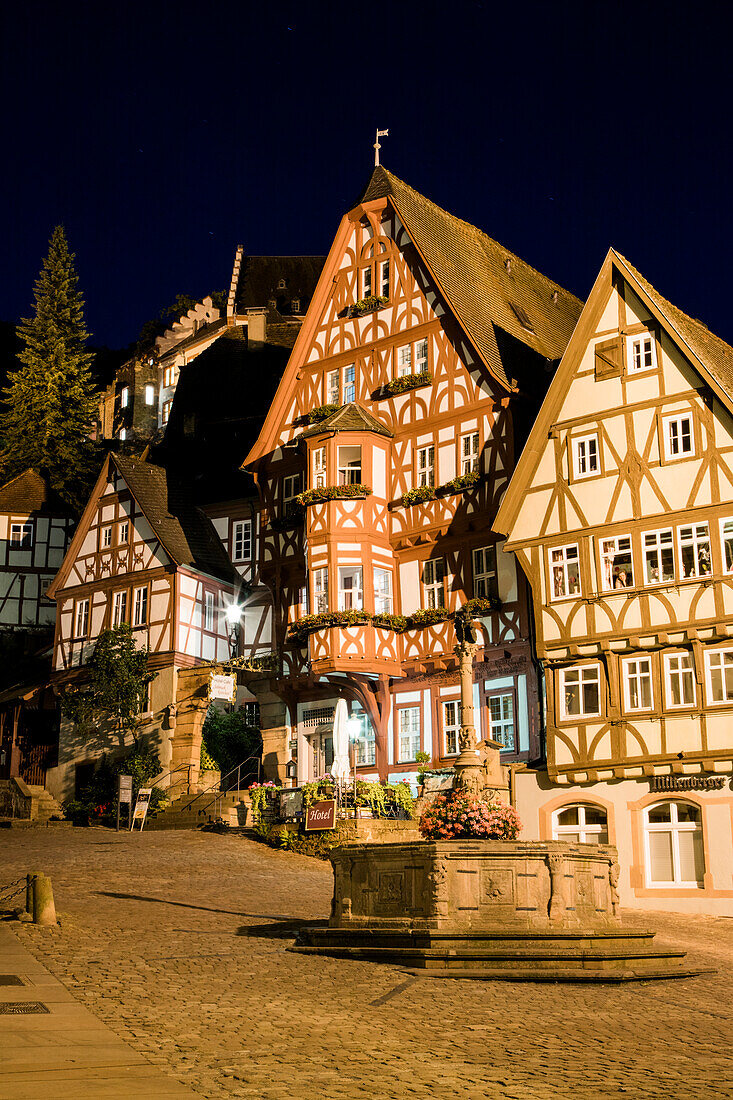 Alter Brunnen und Fachwerkhaus Hotel Café Schmuckkästchen in der Altstadt bei Nacht, Miltenberg, Spessart-Mainland, Bayern, Deutschland