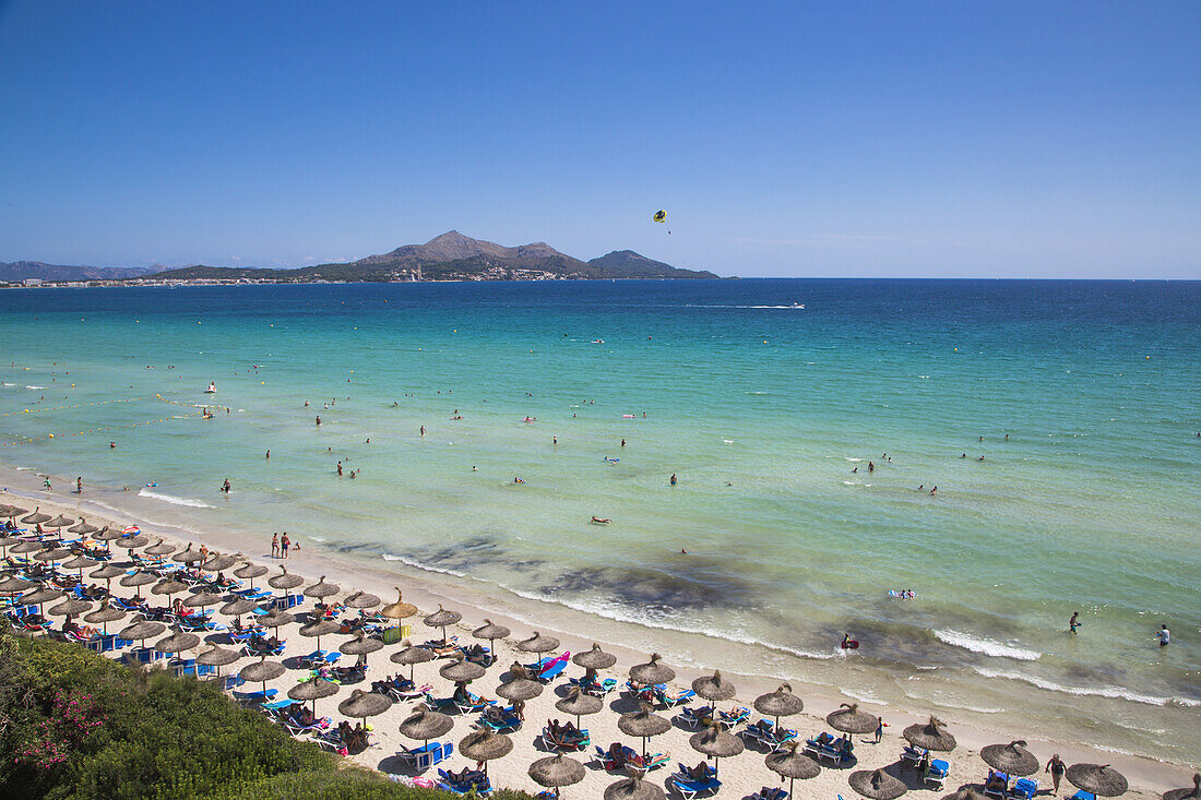 Blick vom Hotel Playa Esperanza Resort auf Sonnenschirme und Menschen am Strand Playa de Muro, nahe Port d'Alcudia, Mallorca, Balearen, Spanien
