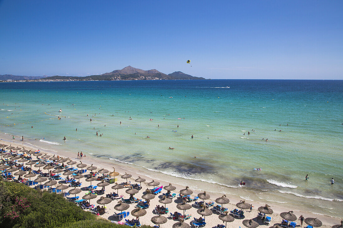 Overhead of sun umbrellas and people on Playa de Muro beach from Playa Esperanza Resort, near Port d'Alcudia, Mallorca, Balearic Islands, Spain