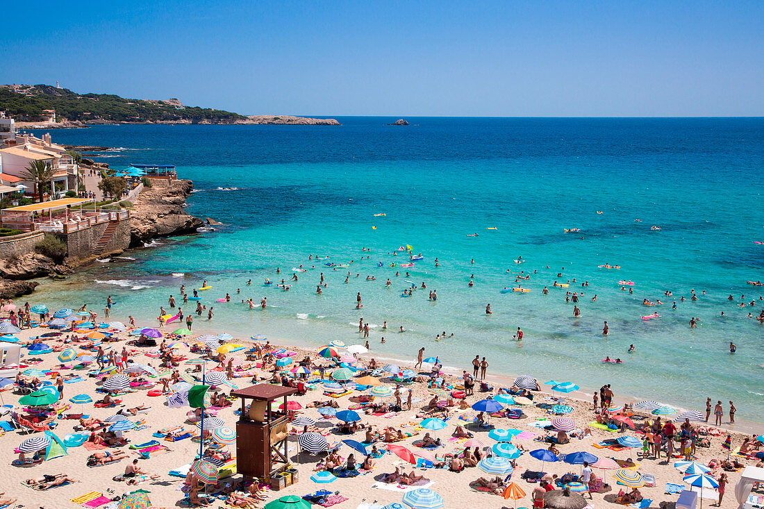 Menschenmenge am Strand der Bucht von Cala Ratjada während der Hauptsaison, Mallorca, Balearen, Spanien