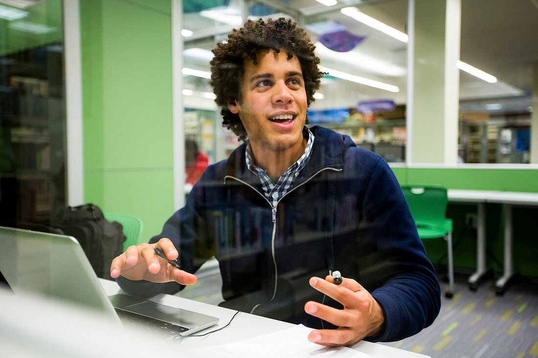 Mixed Race student using laptop in library