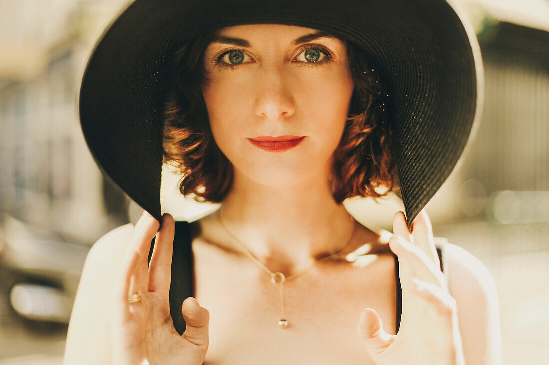 Glamorous Caucasian woman holding hat