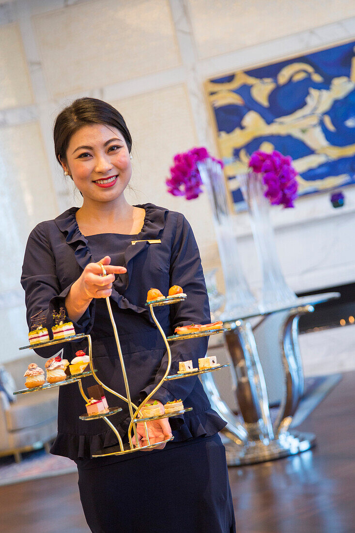 Waitress serves sophisticated high-tea in The Ritz-Carlton Bar & Lounge on 51st Floor of Ritz-Carlton, Macau hotel in Galaxy Macau building complex, Cotai, Macau, China