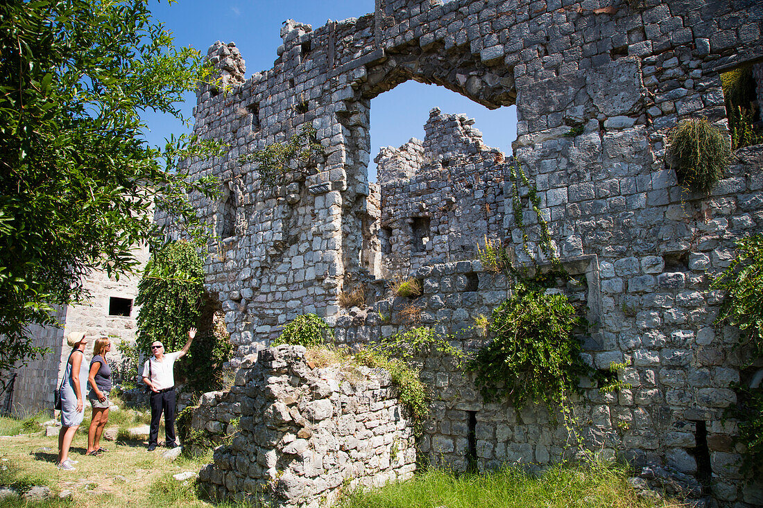 Kreuzfahrtdirektor und Tourguide Dietmar Van De Rydt von Motorsegler Kreuzfahrtschiff M/S Panorama (Variety Cruises) erläutert zwei Frauen die Ruinen der historischen Altstadt Stari Bar, Bar, Montenegro