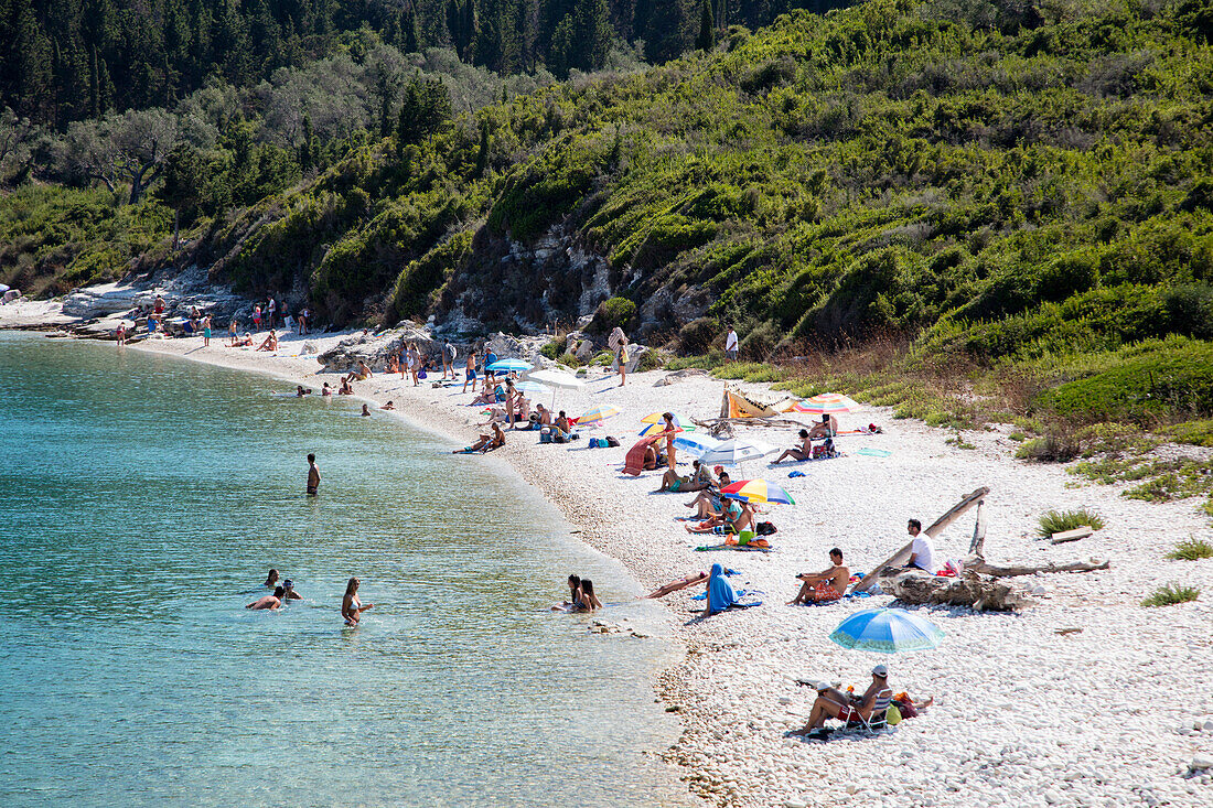 Blick auf relaxende Menschen am Strand, Paxos, Ionische Inseln, Griechenland