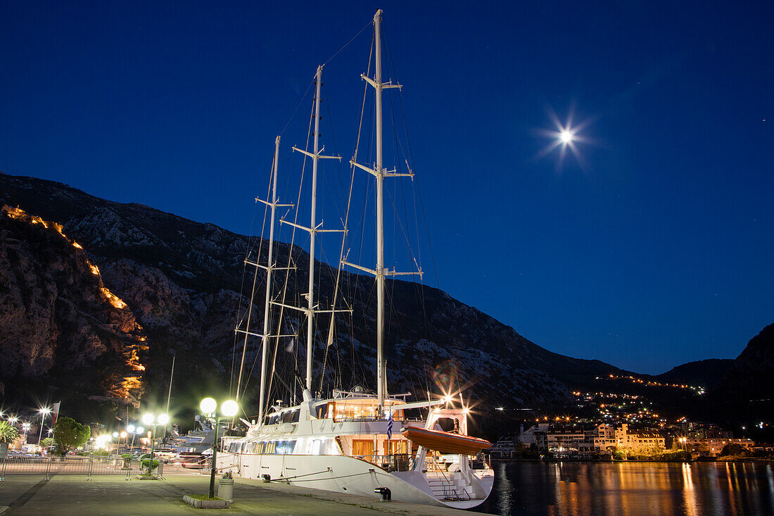 Motor sailing cruise ship M/S Panorama (Variety Cruises) at pier with moon and illuminated Sveti Ivan fortress at night, Kotor, Montenegro