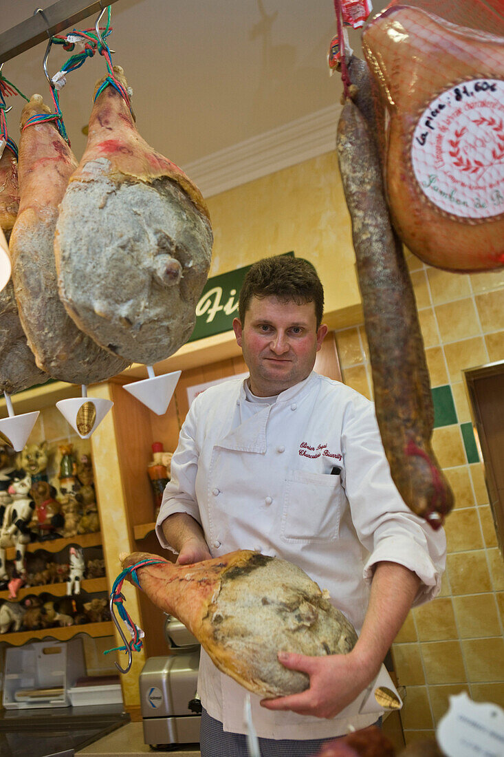 France, Pyrenees Atlantiques, Biarritz, Olivier Paqui, pork butcher with his Jambon de Bayonne (typical dried salted ham from Bayonne) of Charcuterie Paqui