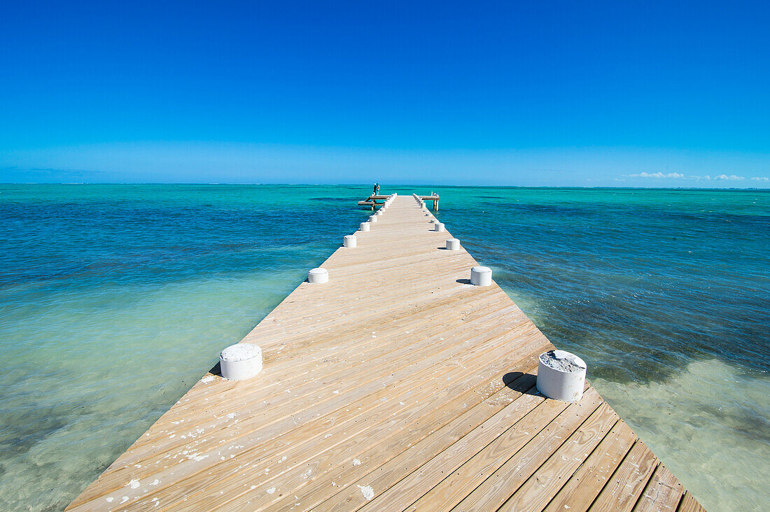 Long wooden pier in the turquoise waters of Providenciales, Turks and Caicos, Caribbean, Central America