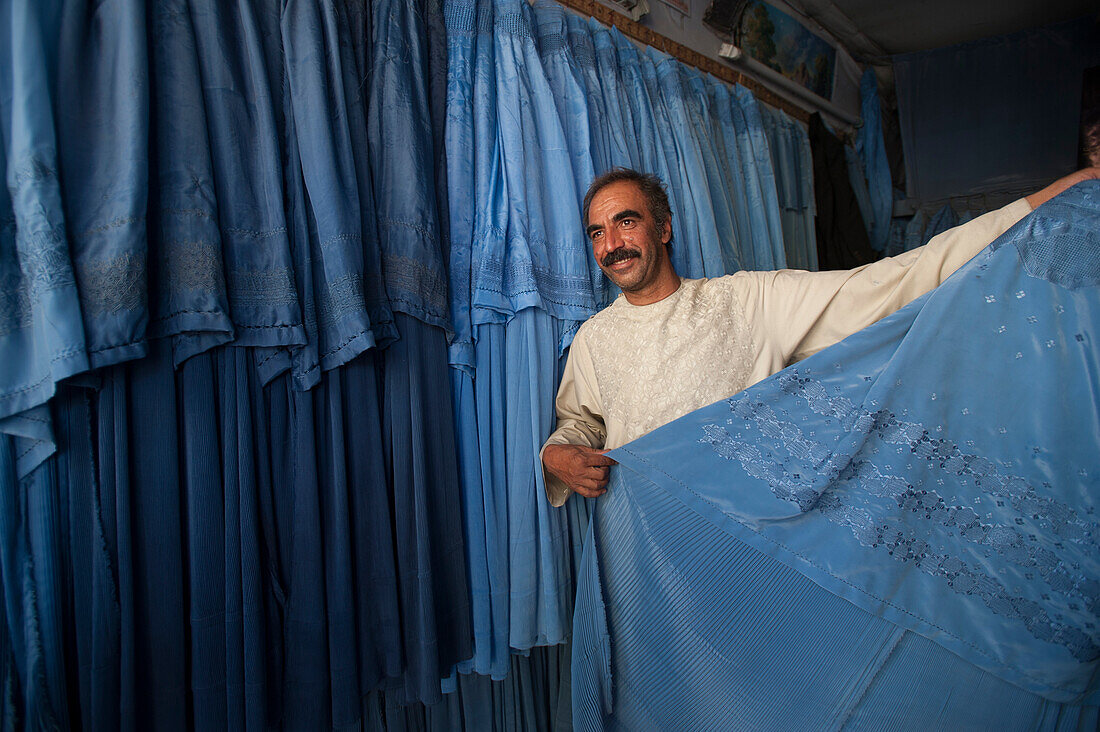 A shopkeeper demonstrates that not all burqas are identical, Herat, Afghanistan, Asia