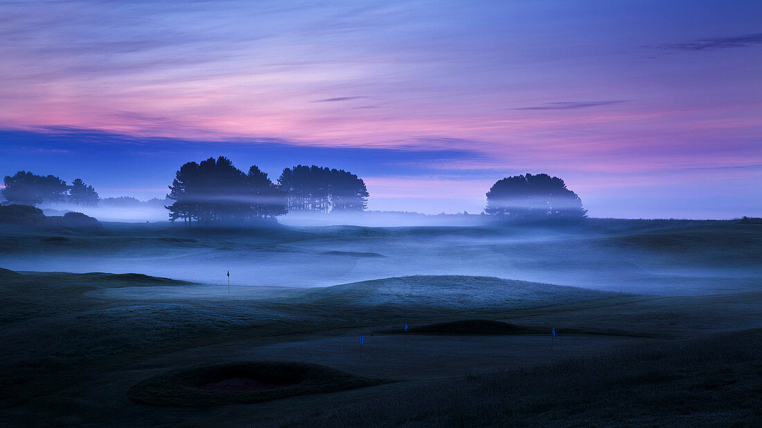 Spring mist lies in the cold undulating valleys across the greens and fairways at Delamere Forest Golf Club, Cheshire, England, United Kingdom, Europe