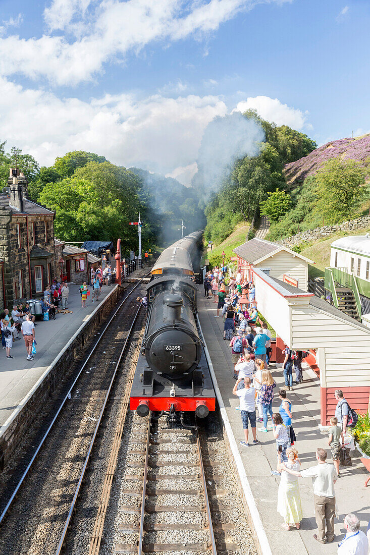Goathland station and a steam locomotive pulling in from Grosmont, on the North Yorkshire Moors Steam Railway, Goathland, Yorkshire, England, United Kingdom, Europe