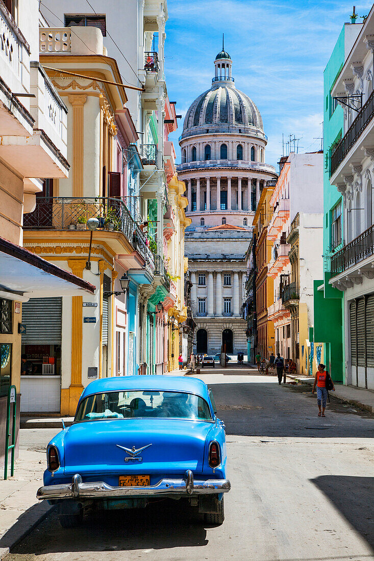 A classic car parked on the street next to colonial buildings with the former Parliament Building in the background, Havana, Cuba, West Indies, Caribbean, Central America