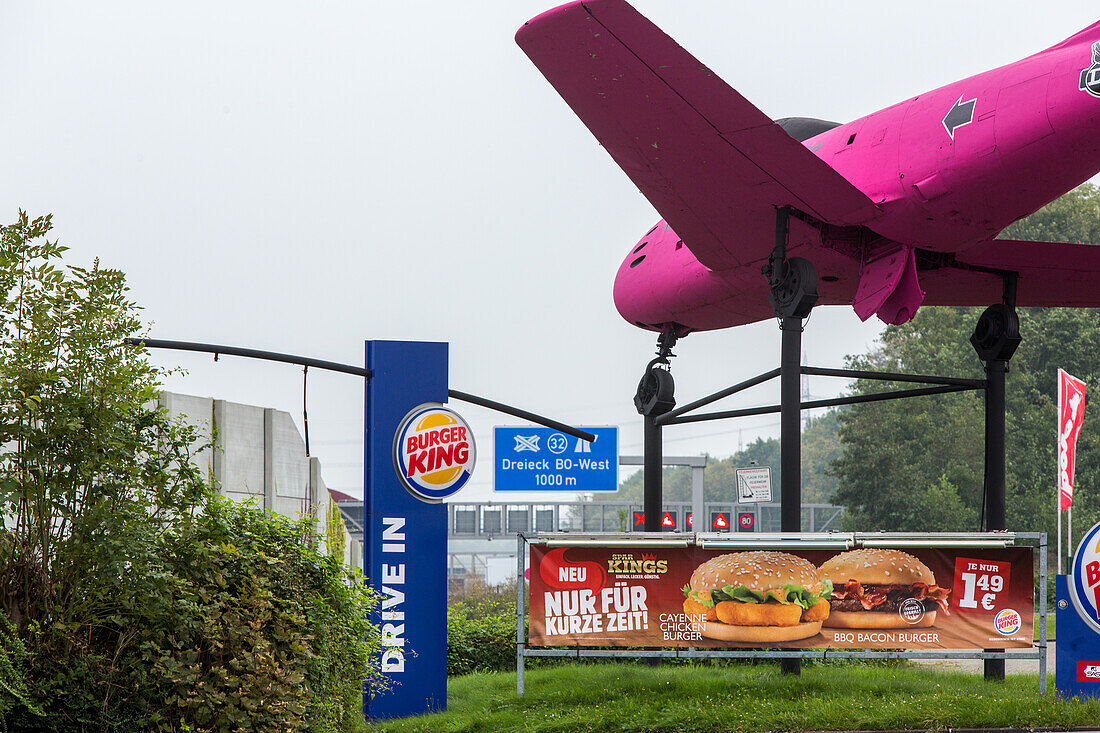 A 40 bei Bochum, Reklame, Werbung, Flugzeugattrape, Fastfood neben Deutsche Autobahn, Verkehr, Verkehrsnetz, Transit, LKW, Maut, Dämmerung, Beschilderung, Individualverkehr, Deutschland