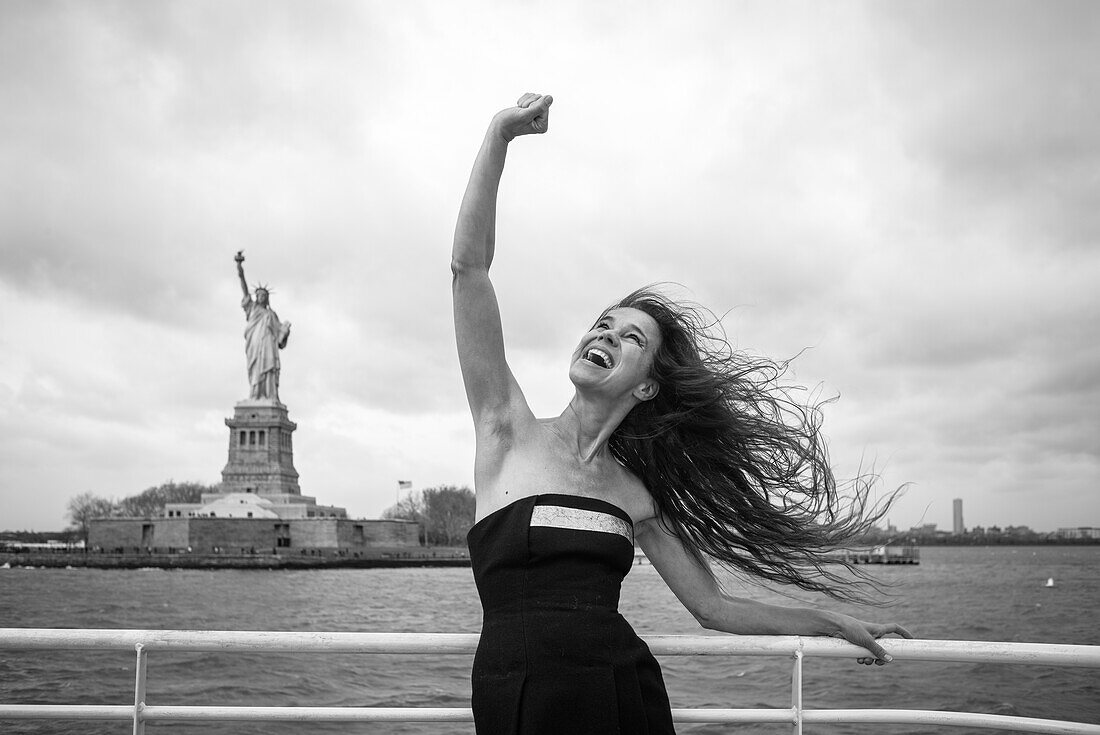 Woman in front of the Statue of liberty, New York City, New York, USA