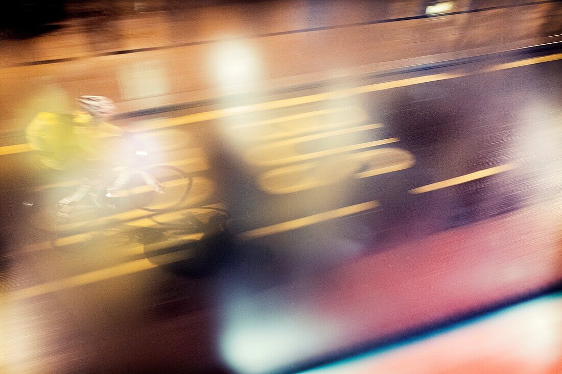Vista desde la ventana de un auto bus de un ciclista irreconocible en movimiento circulando en el carril bus, y reflejos en el cristal de la ventana London, Reino Unido, Europa