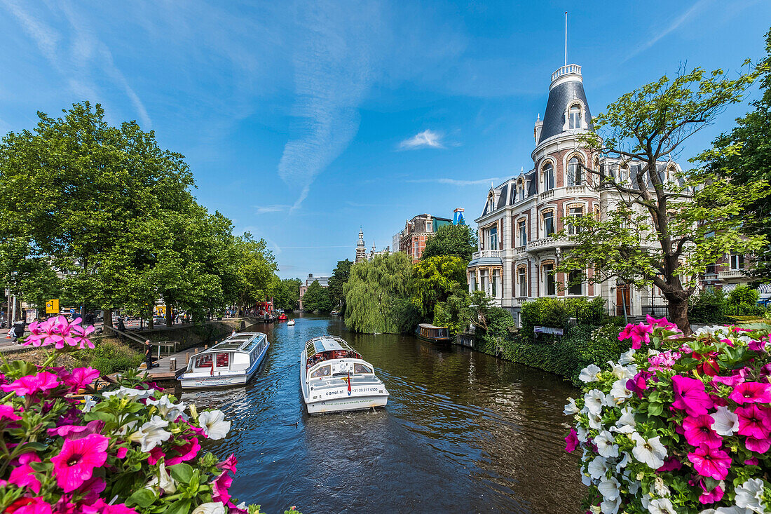view to canal boats and houses from the Museumsbrug in Amsterdam, Netherlands