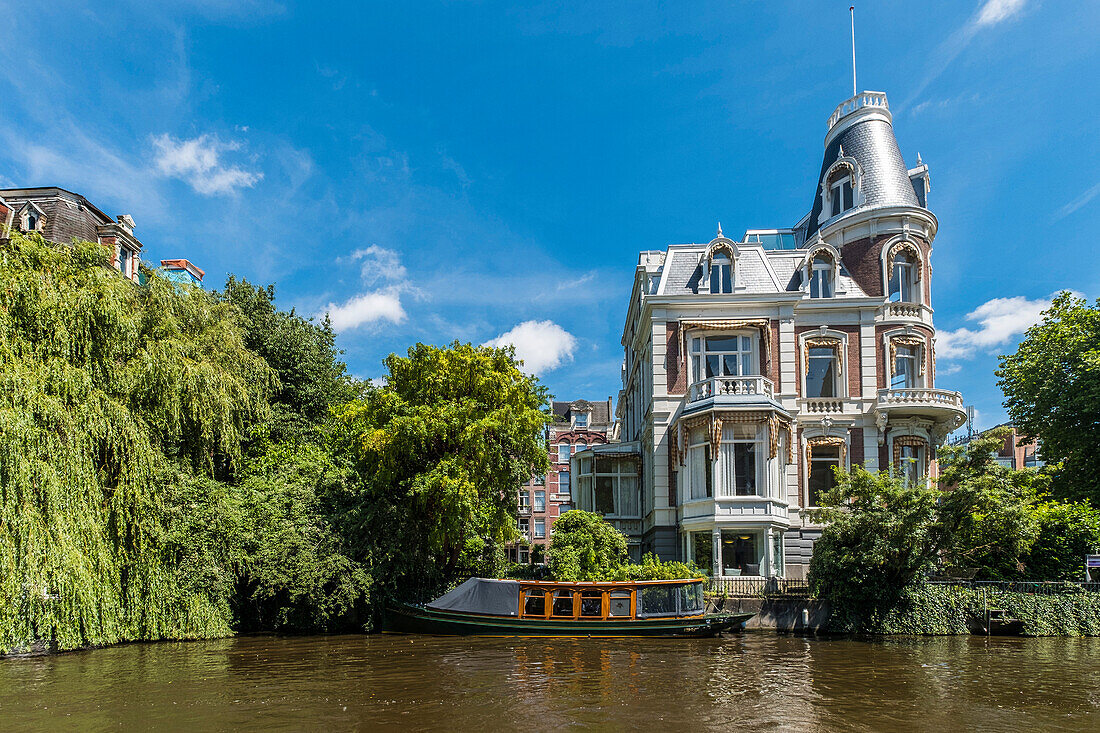 Blick auf Canalschiffe und Wohnhäuser an der Museumsbrug in Amsterdam, Holland