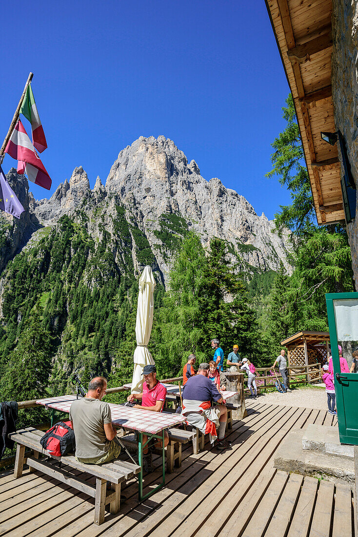 Several persons sitting on terrace of hut Rifugio Treviso Val Canali, Val Canali, Pala Group, Dolomites, UNESCO World Heritage Site Dolomites, Trentino, Italy