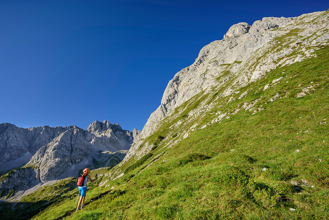 Woman hiking towards Ehrwalder Sonnenspitze, Ehrwalder Sonnenspitze, Mieming range, Tyrol, Austria