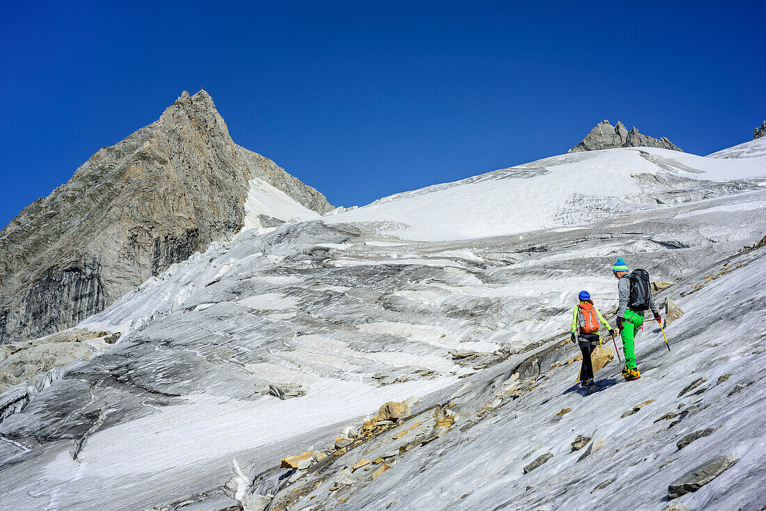 Man and woman ascending on glacier Kuchelmoosferner, Kuchelmooskopf in background, Zillergrund, Reichenspitze group, Zillertal Alps, Tyrol, Austria