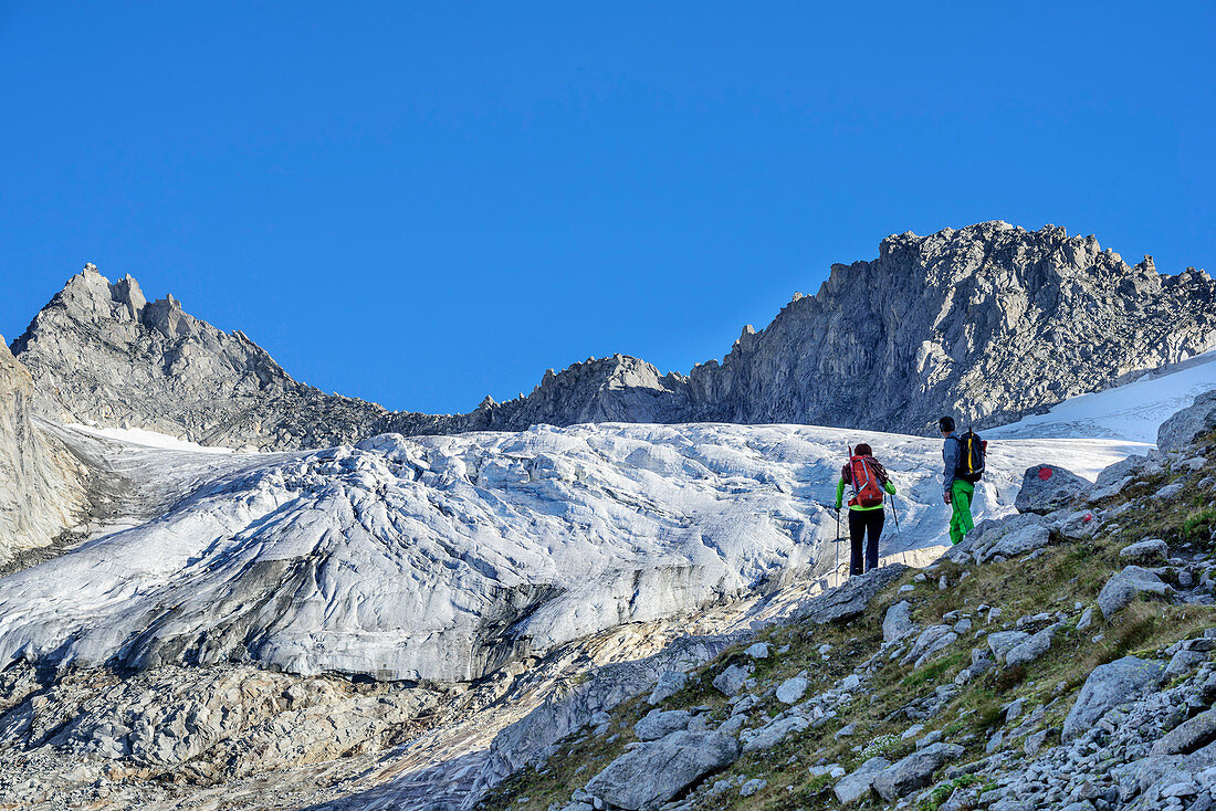 Two persons ascending to Reichenspitze, glacier Kuchelmoosferner and Wildgerlosspitze in background, Zillergrund, Reichenspitze group, Zillertal Alps, Tyrol, Austria