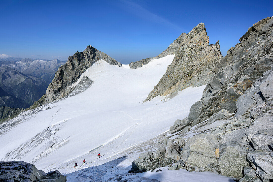 Three persons ascending to Reichenspitze, Kuchelmooskopf and Hahnenkamm in background, Reichenspitze, Zillergrund, Reichenspitze group, Zillertal Alps, Tyrol, Austria