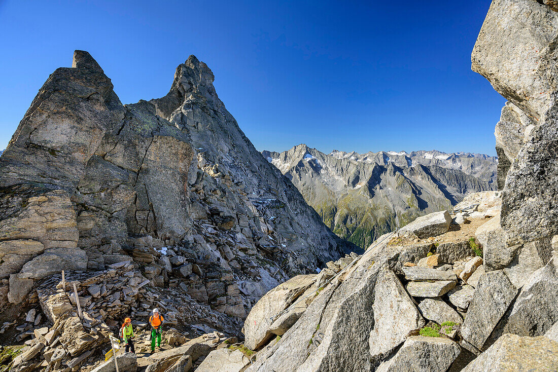 Man and woman standing in notch, Richterspitze, Reichenspitze group, Zillertal Alps, Tyrol, Austria