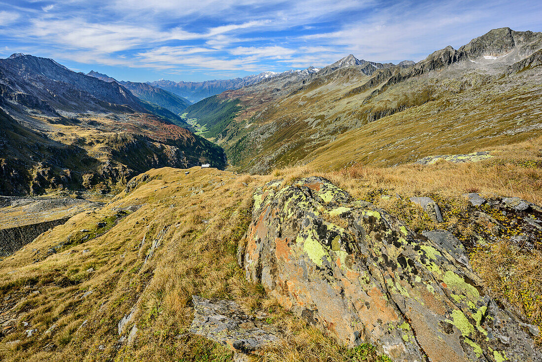 Rock with lichen covered, view to valley Ahrntal in background, from pass Birnluecke, National Park Hohe Tauern, Dreilaendertour, Zillertal Alps, South Tyrol, Italy