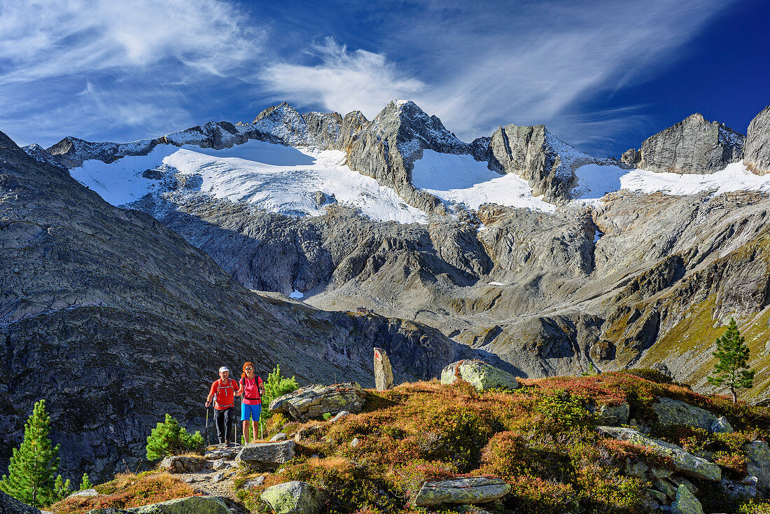 Man and woman hiking descending from hut Richterhuette, Reichenspitz-Group in background, hut Richterhuette, Natural Park Zillertal Alps, Dreilaendertour, Zillertal Alps, Salzburg, Austria