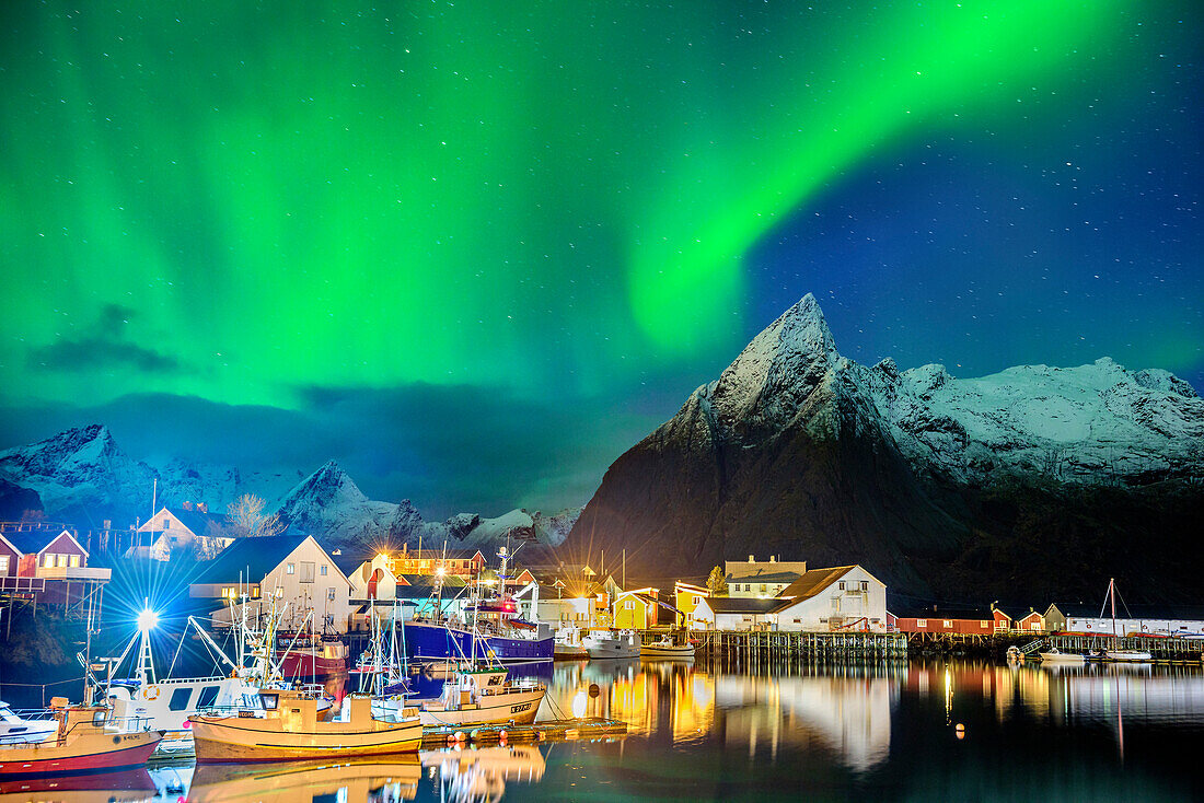 Aurora borealis, Aurora above bay with illuminated boats and houses of Hamnoy, Hamnoy, Lofoten, Norland, Norway