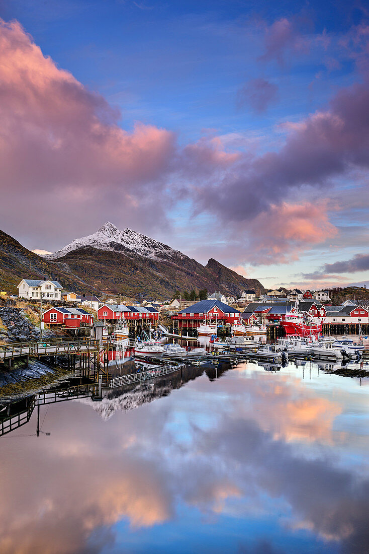 Meeresbucht mit Häusern von Klingenberg und verschneiten Bergen im Hintergrund, Klingenberg, Lofoten, Norland, Norwegen