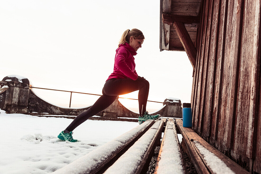 young woman stretching near Lake Starnberg, Bavaria, Germany.