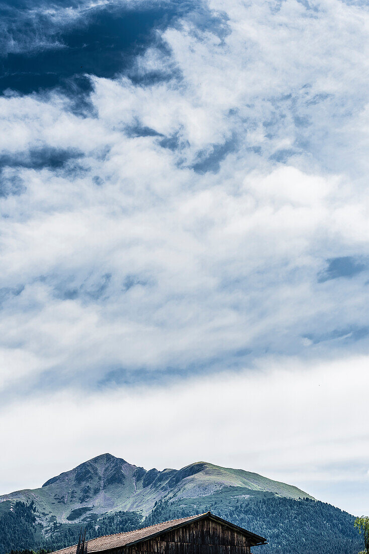 View of the Schwarzhorn behind a wooden shed, Radein, South Tyrol, Italy