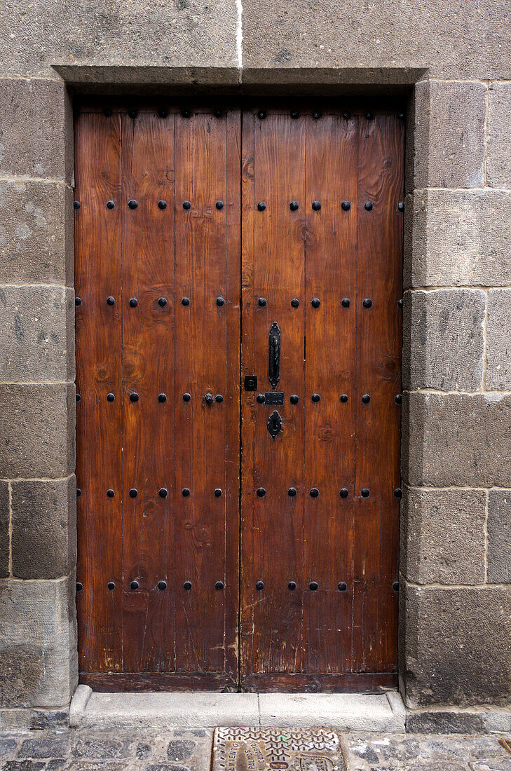 Sixteenth century brown wooden door, with iron fastenings, set in stone doorway, Las Palmas Gran Canaria, Canary Islands, Spain
